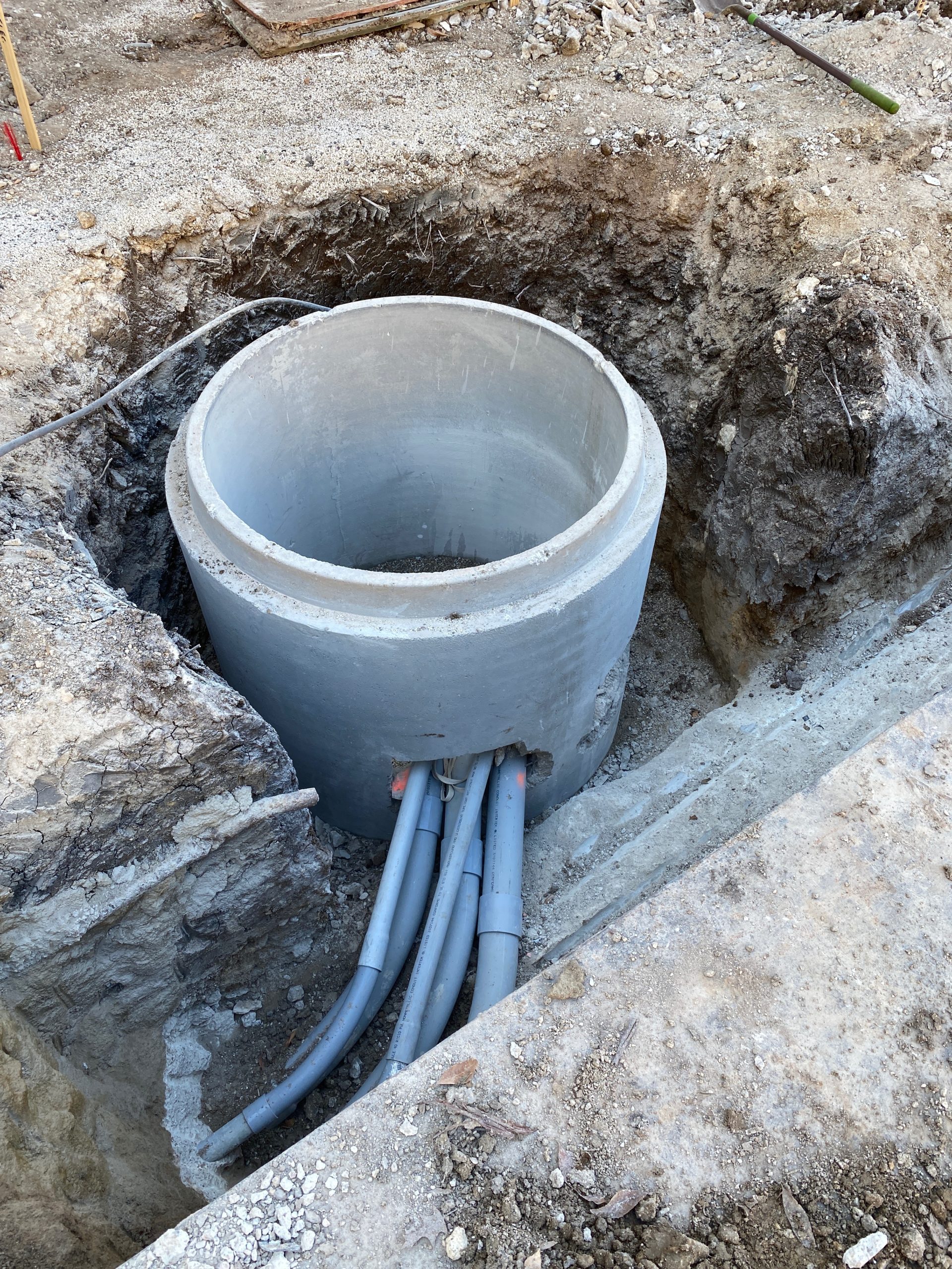 Round concrete tube with smaller pipes coming out.