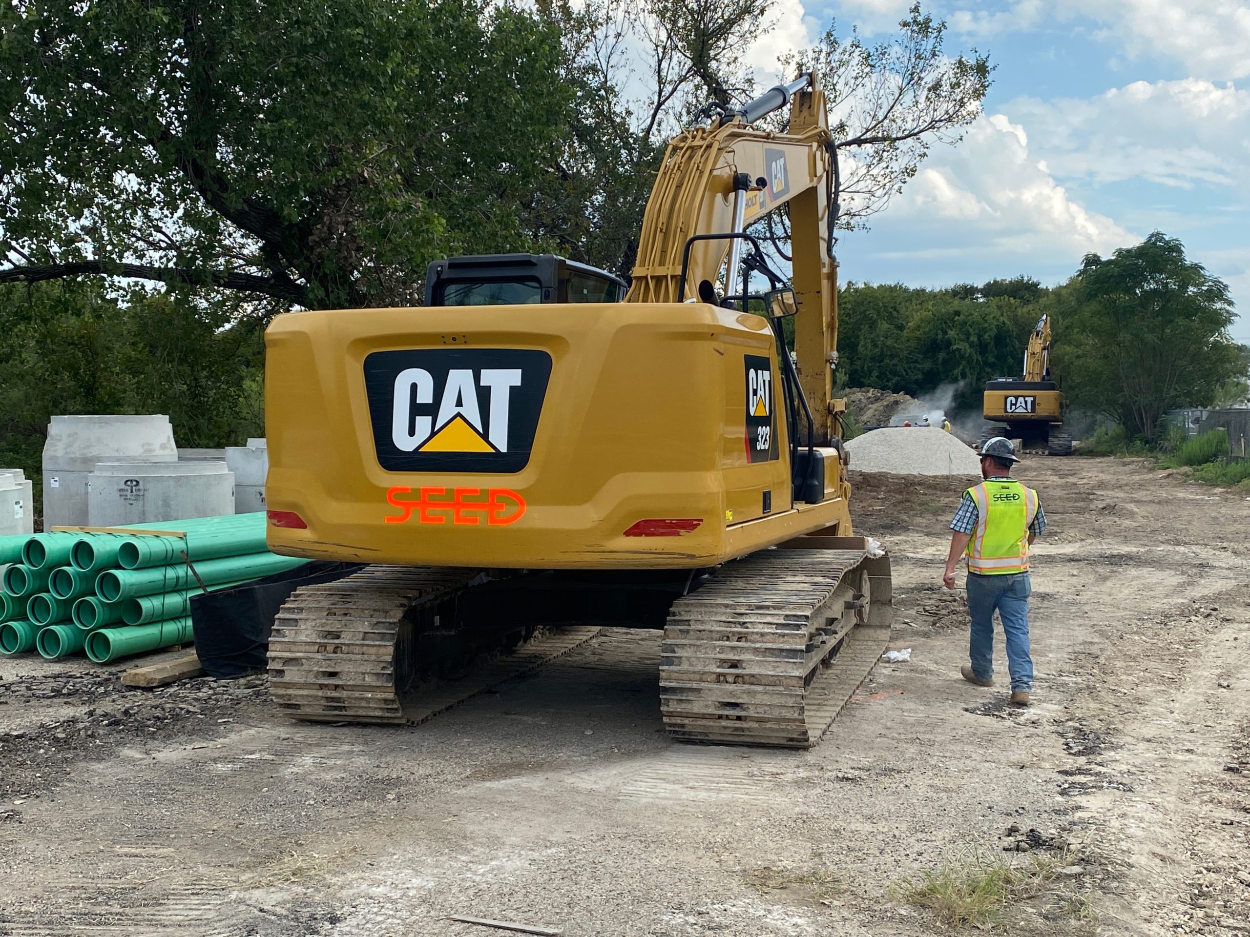 Back end shot of a CAT excavator with seed logo.